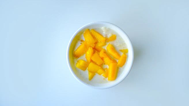 a white bowl filled with fruit on top of a table