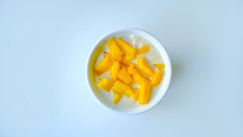 a white bowl filled with fruit on top of a table