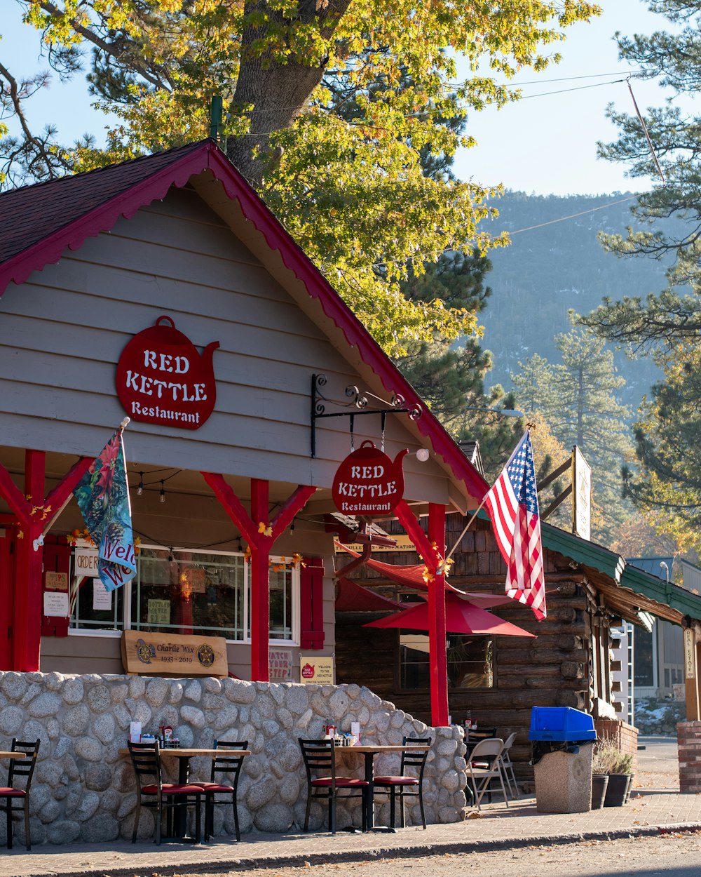 a red kettle restaurant with flags hanging from it's roof