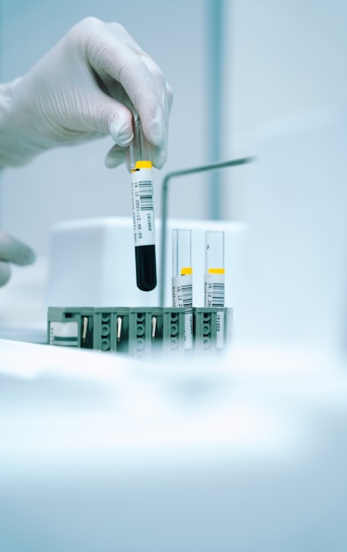 a gloved hand holding a test tube filled with liquid