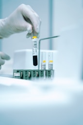 a gloved hand holding a test tube filled with liquid