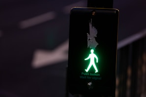 a green pedestrian walk sign on a pole