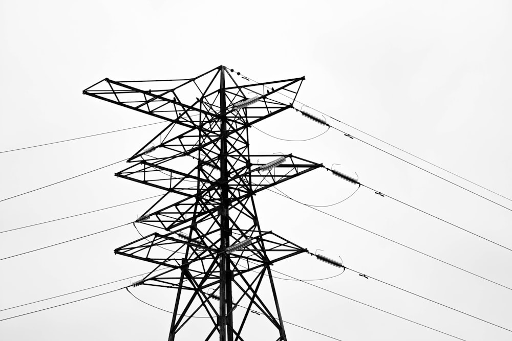 a black and white photo of a high voltage power pole