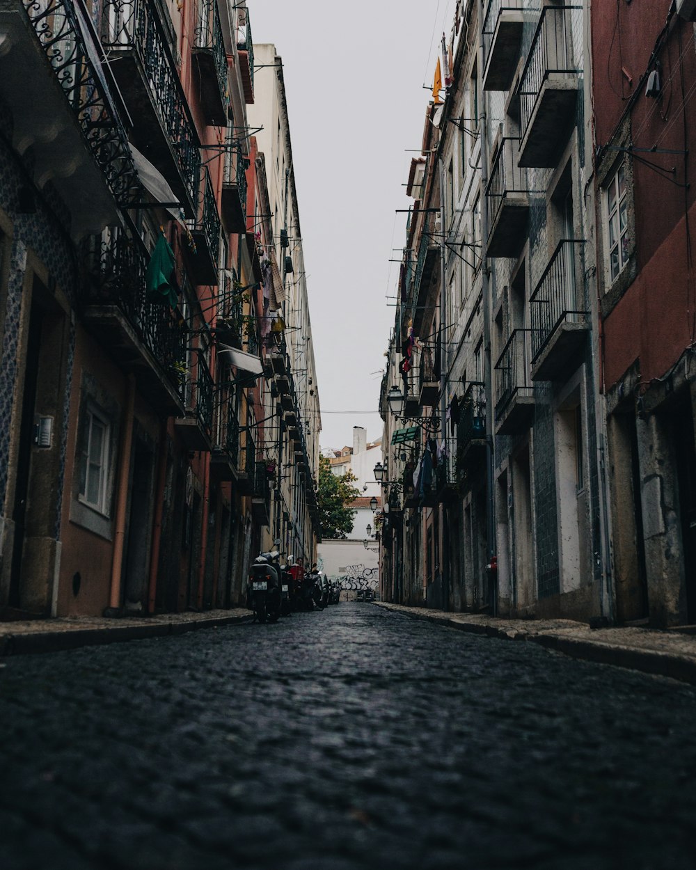 a narrow street lined with tall buildings and balconies