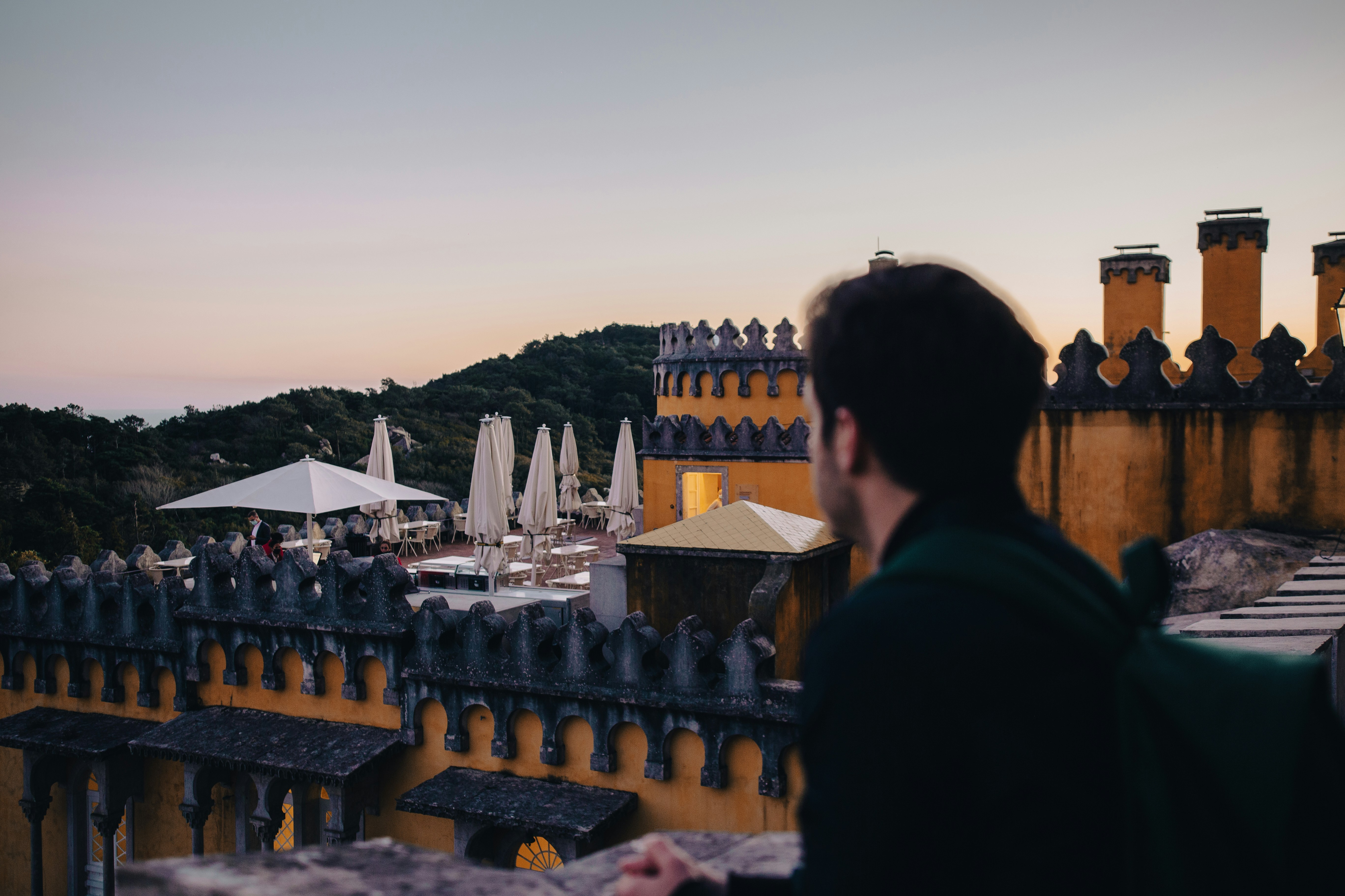 a man standing on top of a roof next to a tall building