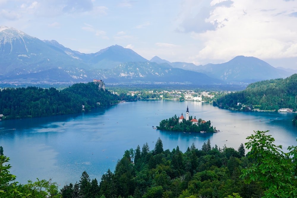 a small island in the middle of a lake surrounded by mountains