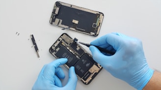 a person in blue gloves is repairing a cell phone