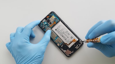 a person in blue gloves is removing a cell phone