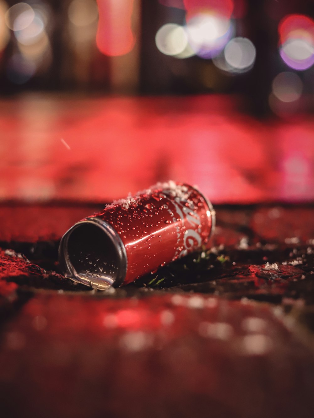 a can of soda sitting on the ground