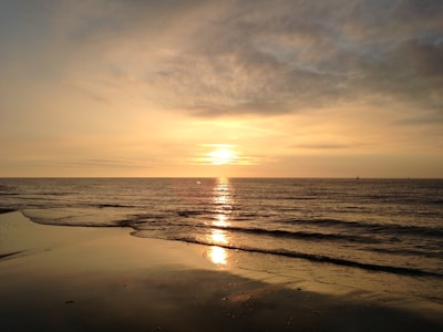 Sunset over the serene beaches of Goa with golden hues reflecting on calm waters.