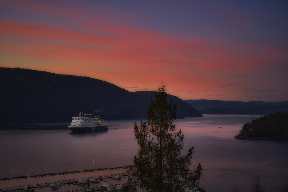 a cruise ship in the water at sunset