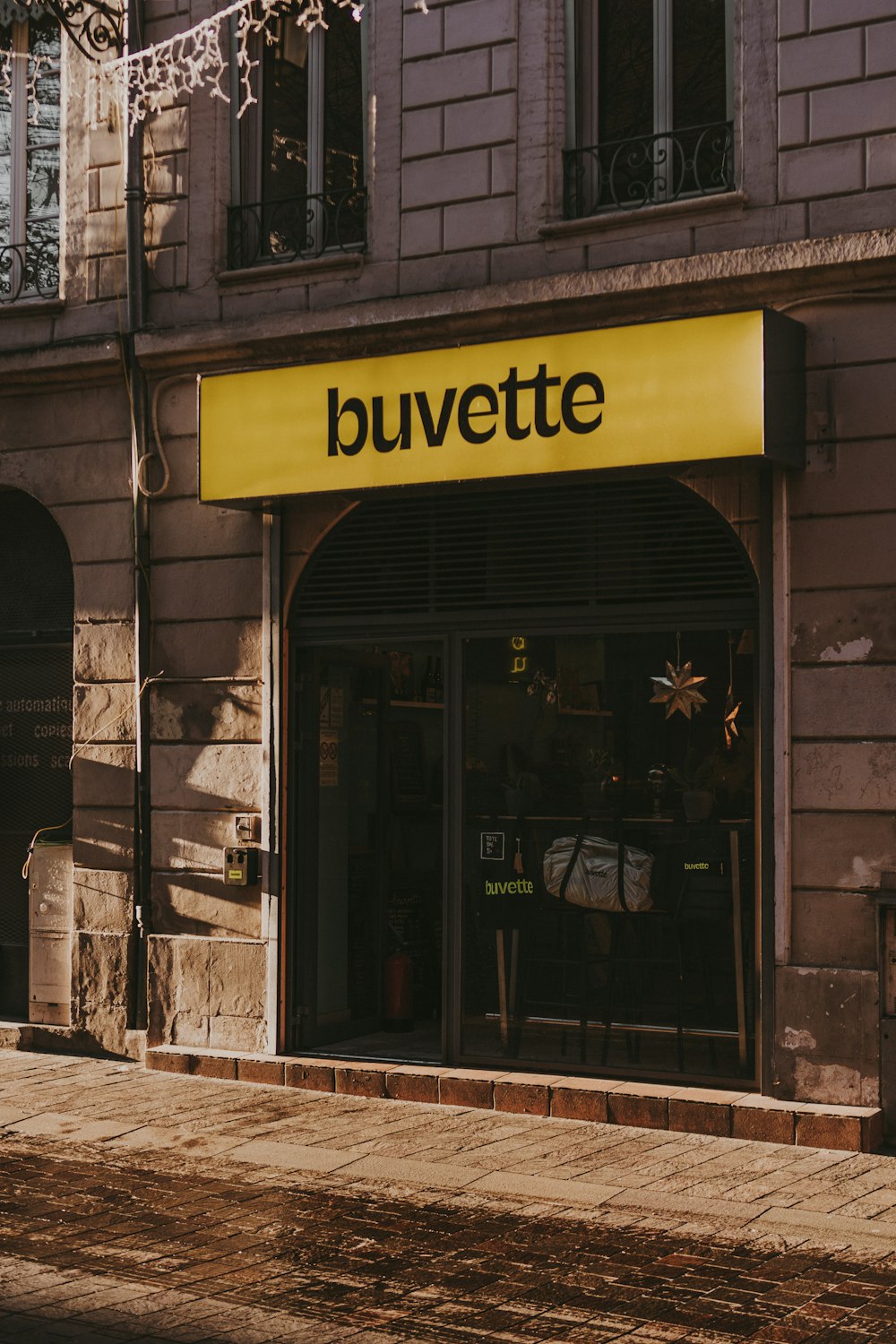 Un frente de tienda con un letrero amarillo que dice Buvette