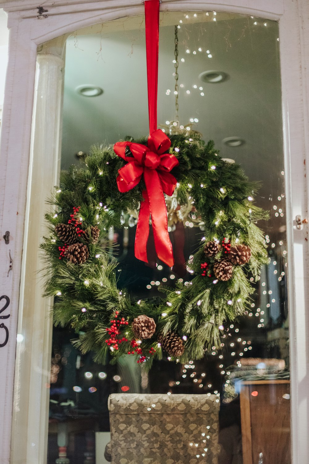 a christmas wreath hanging on the front door of a store