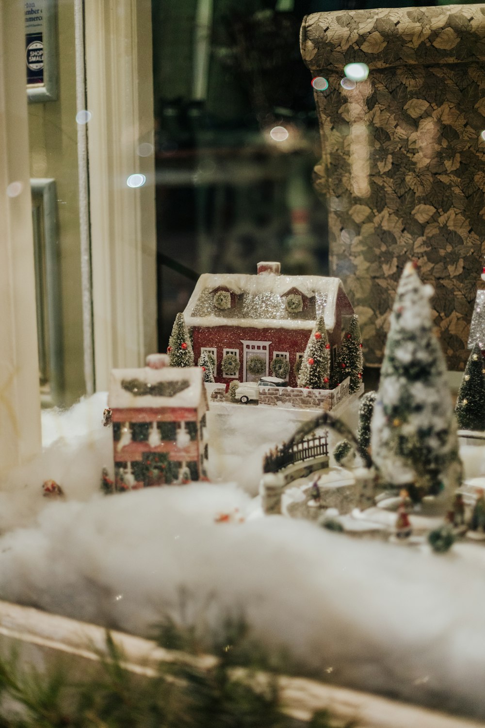a window display with a house and trees in it