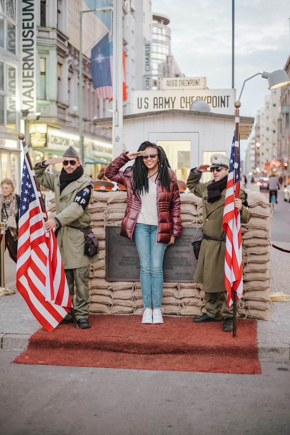 a woman standing in front of a pile of sandbags