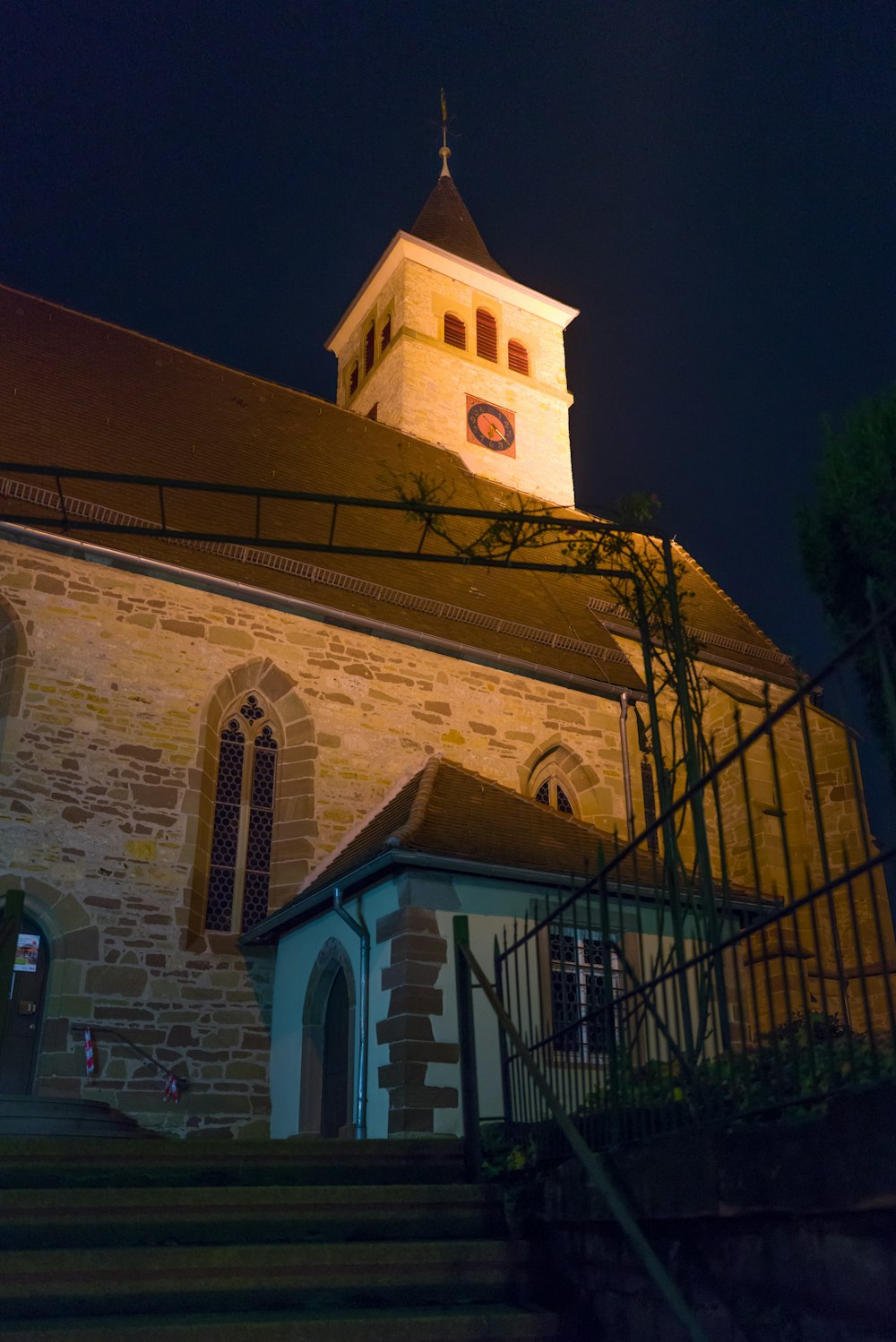 une église avec un clocher éclairé la nuit