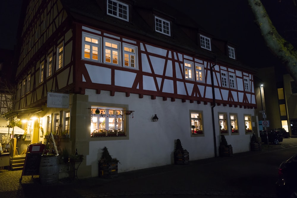 a white and red building with windows lit up at night