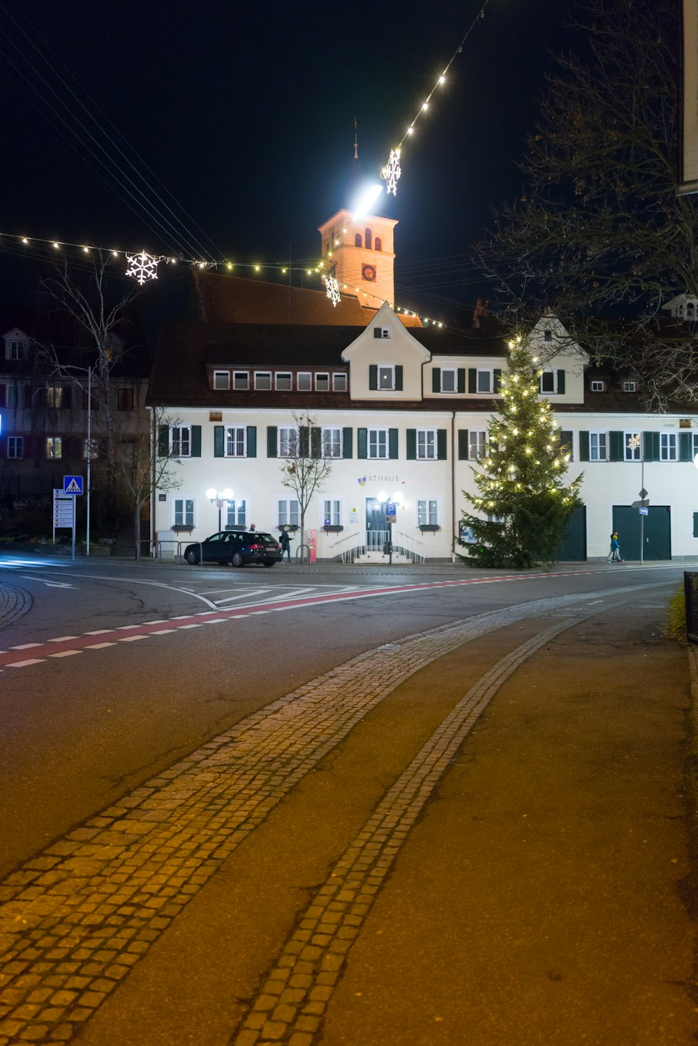 Un grande edificio bianco con un albero di Natale di fronte