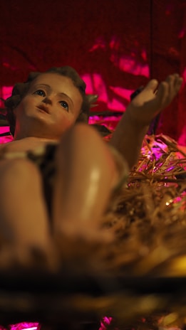 Warm ivory sculpture of a newborn cradled gently in hands, bathed in soft light.