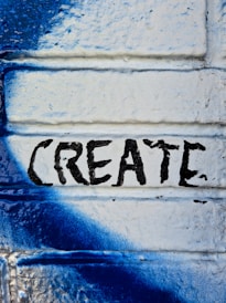 a blue and white painted brick wall with the word create painted on it