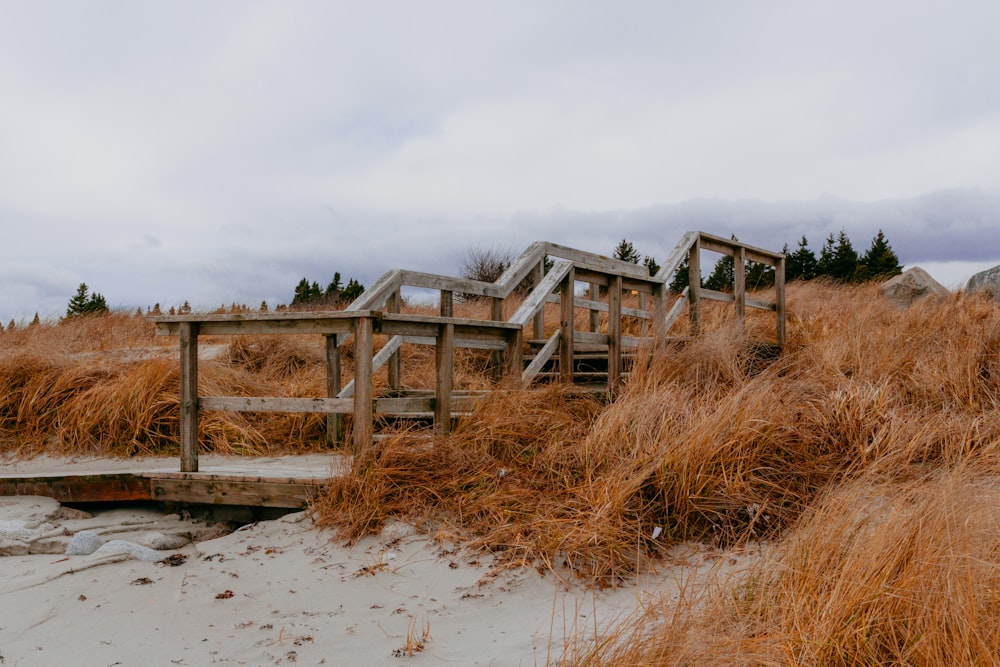 a wooden bridge over a sandy beach