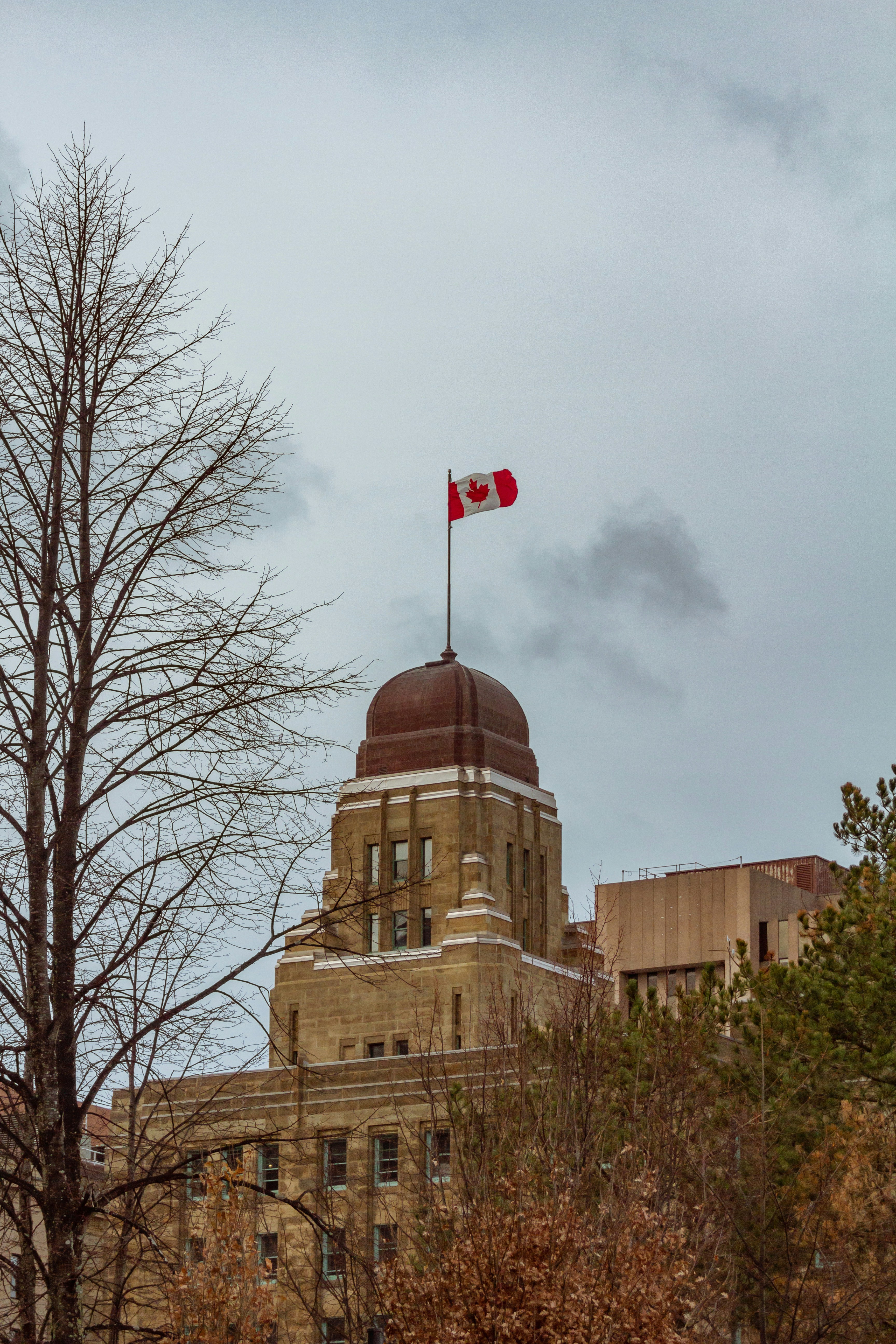 a canadian flag flying on top of a building