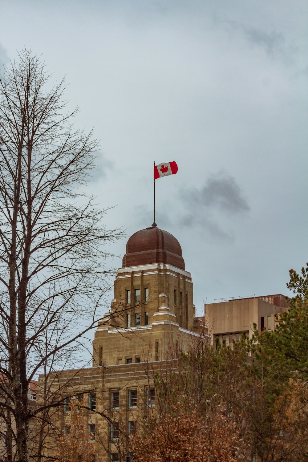 a canadian flag flying on top of a building