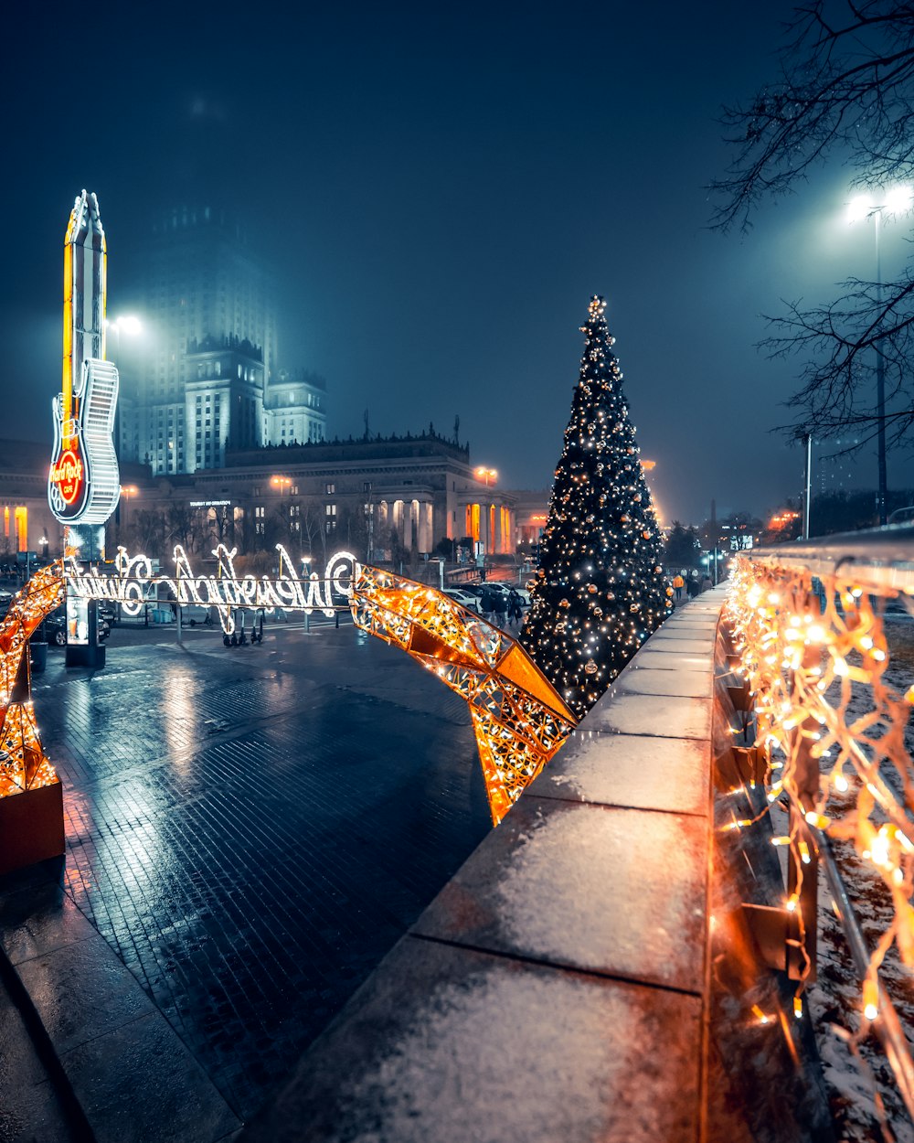 a christmas tree is lit up in front of a building