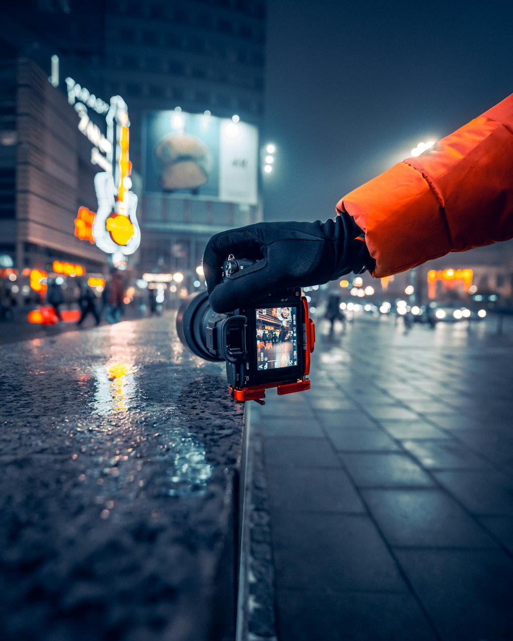 a person in an orange jacket is holding a camera