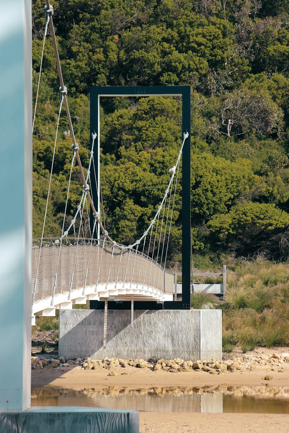 a bridge over a body of water with trees in the background