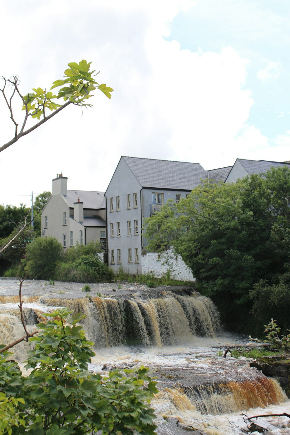 a large building sitting next to a waterfall