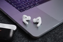 a pair of ear buds sitting on top of a laptop