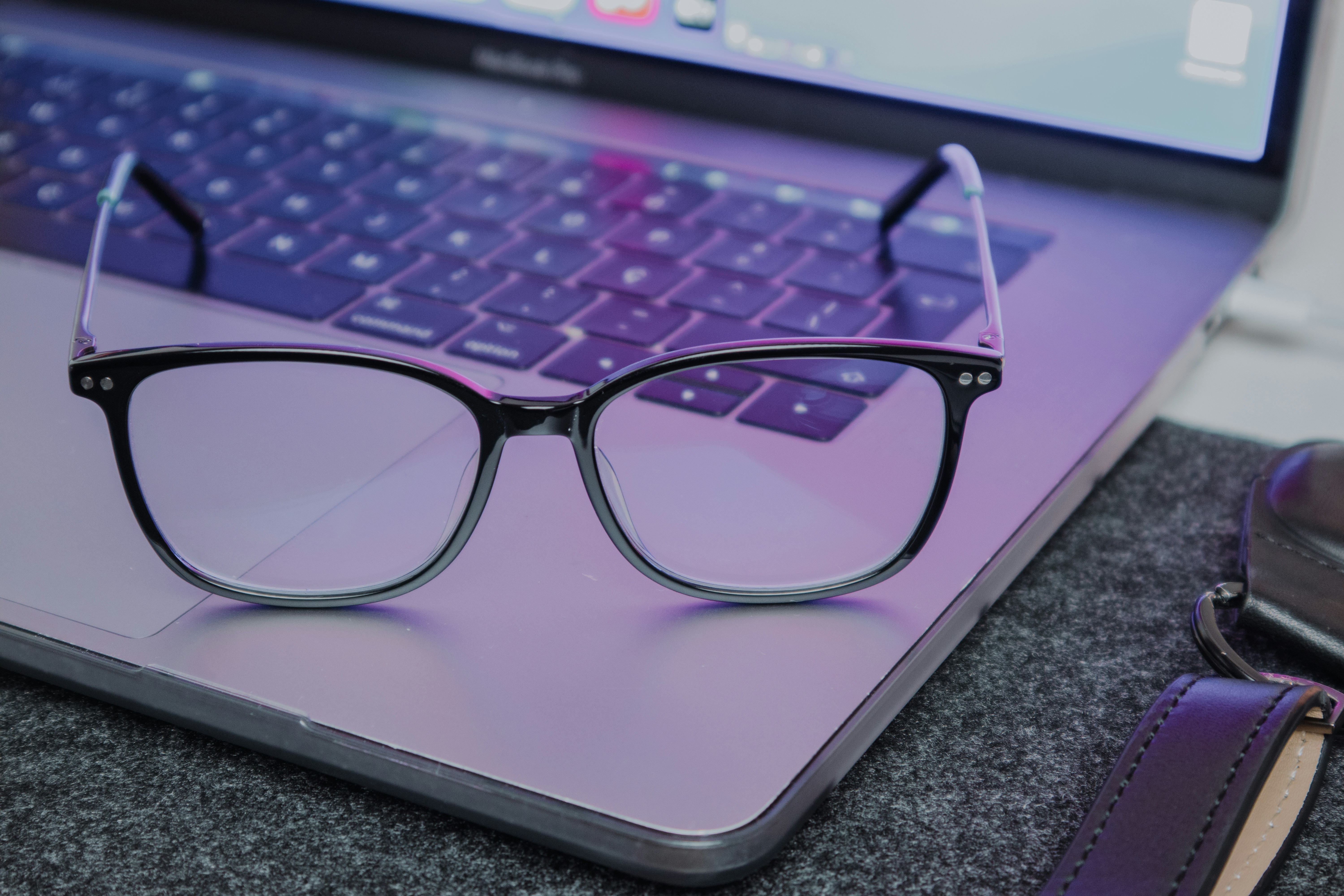 a pair of glasses sitting on top of a laptop