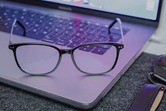 a pair of glasses sitting on top of a laptop