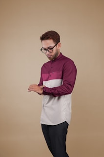 a man wearing glasses and a maroon and white shirt