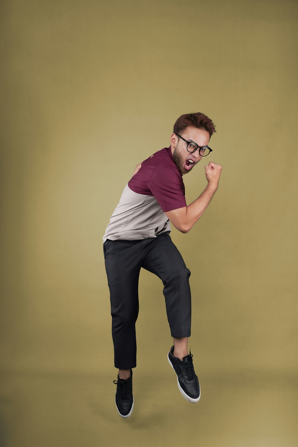 a man jumping in the air while wearing glasses