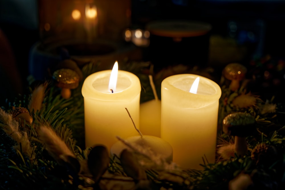 three lit candles sitting on top of a table