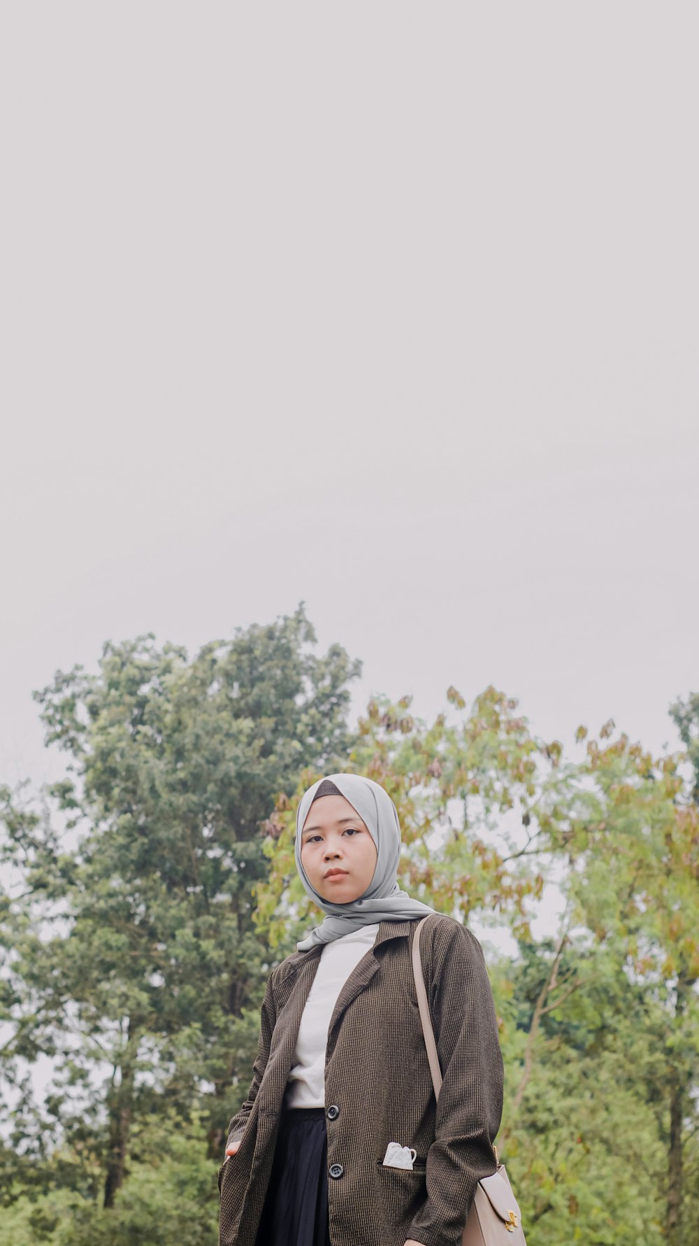 a woman in a hijab standing in a field