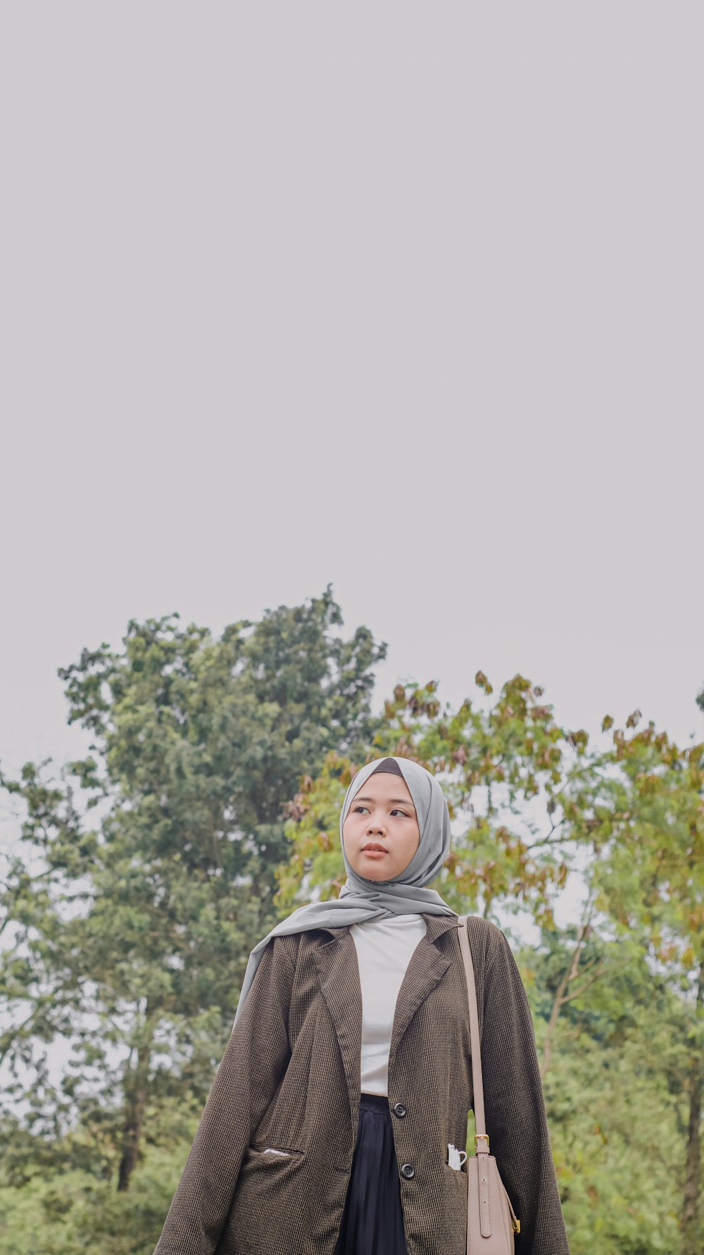 a woman in a hijab is standing in a field