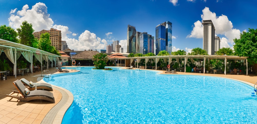 a large swimming pool with lounge chairs around it