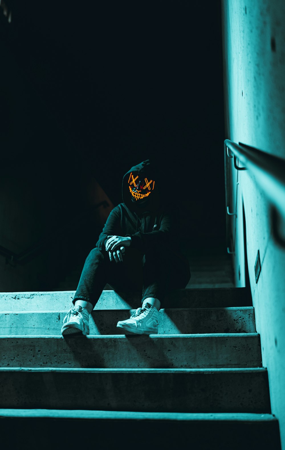 a person wearing a mask sitting on some stairs