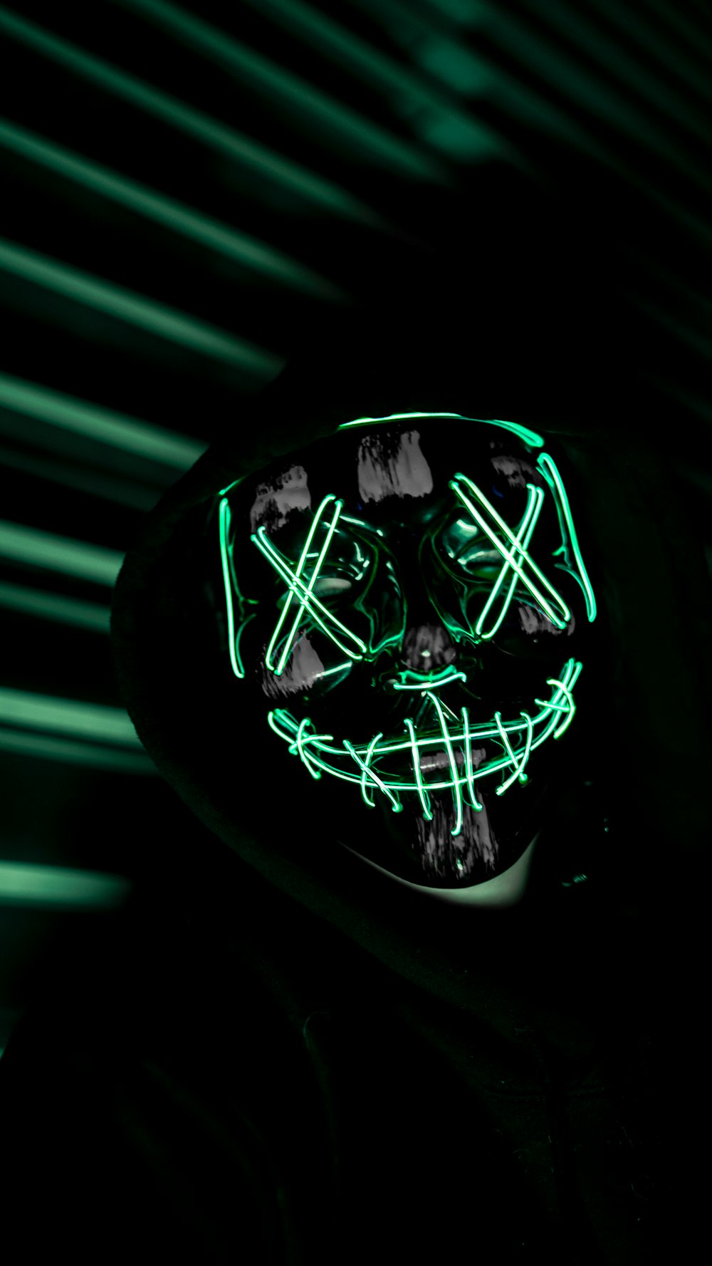 a person wearing a neon mask in the dark