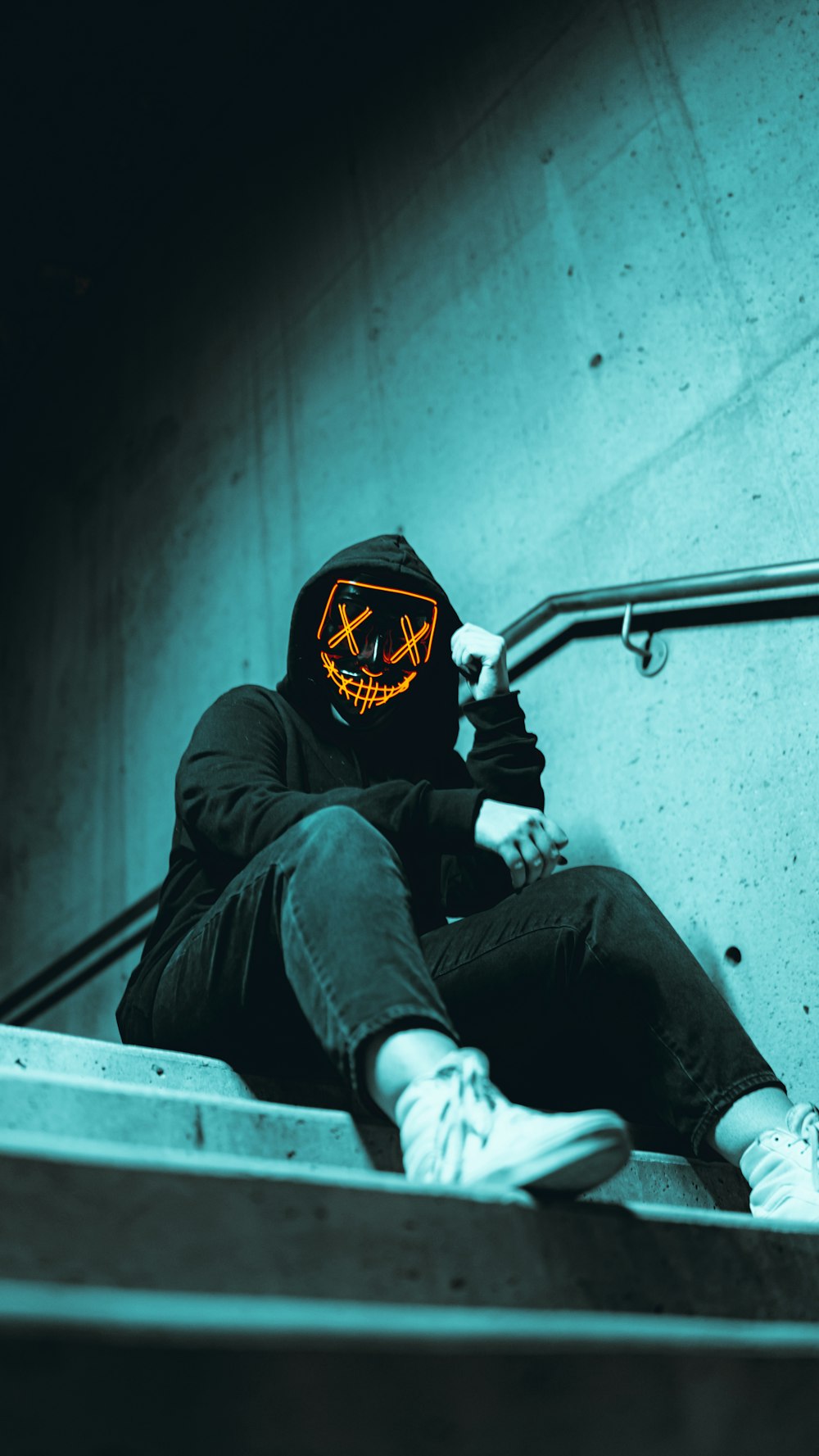 a person wearing a mask sitting on a set of stairs