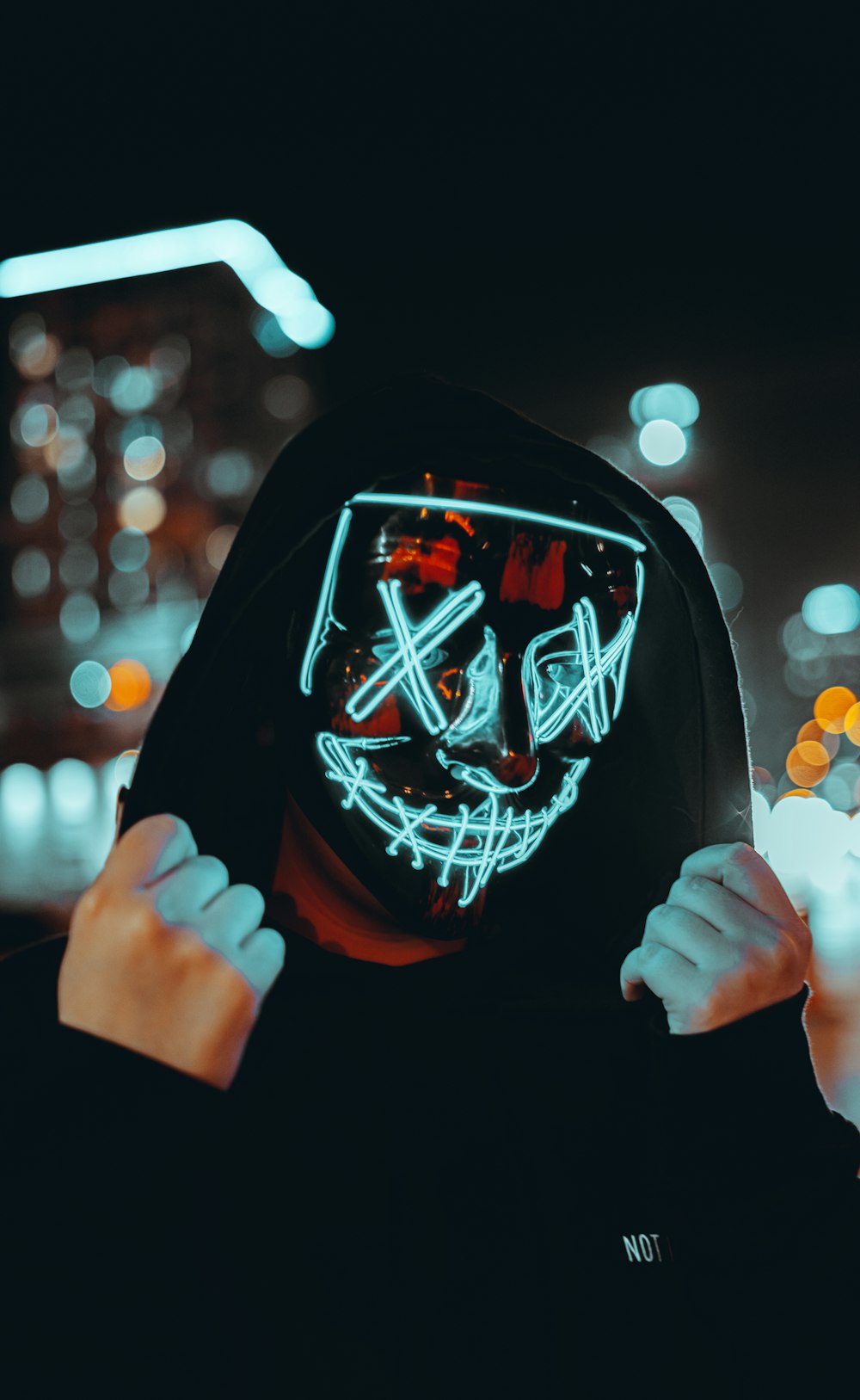 a person wearing a neon mask in the dark