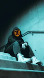 a person wearing a hoodie sitting on a set of stairs