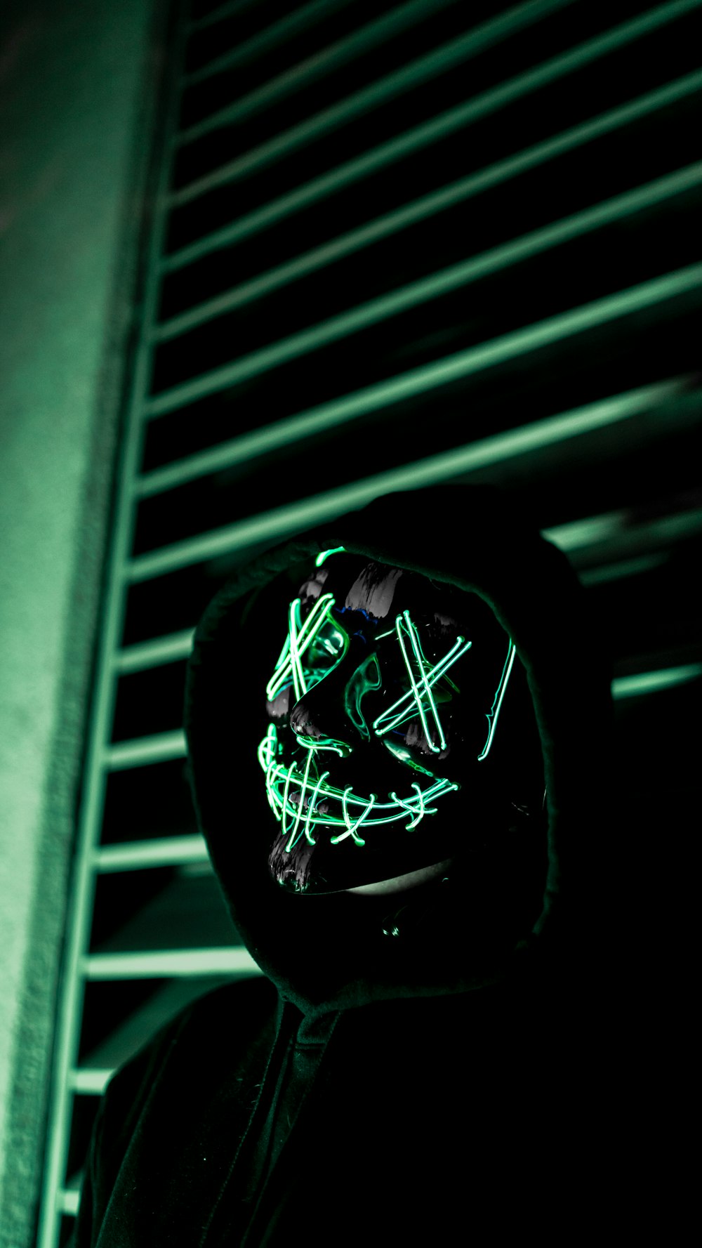 a person wearing a neon mask in the dark