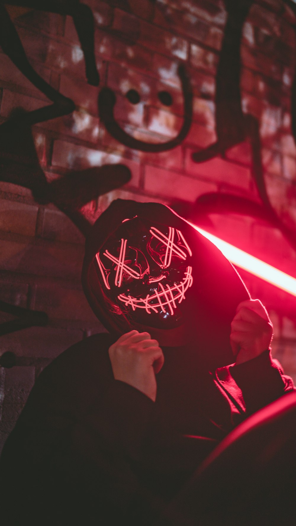 a man wearing a mask with a red light behind him