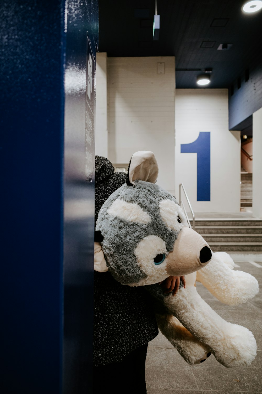 a person is holding a large stuffed animal