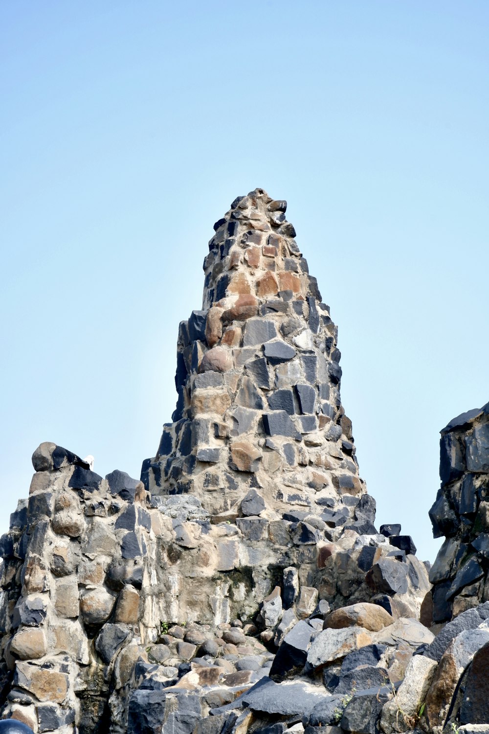 a very tall stone tower with a sky background