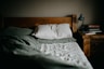 Empty bed at night with soft fluorescent light — steady brown noise environment for anxiety relief